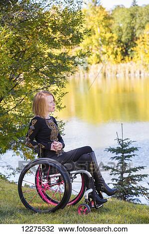 Young disabled woman in a wheelchair in a city park in autumn; Edmonton, Alberta, Canada View Large Photo Image Stock Image - Young disabled woman in a wheelchair in a city park in autumn; Edmonton, Alberta, Canada. Fotosearch