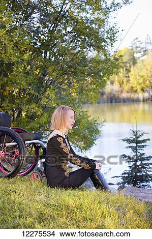 Young disabled woman sitting beside her wheelchair in a city park in autumn; Edmonton, Alberta, Canada View Large Photo Image Picture - Young disabled woman sitting beside her wheelchair in a city park in autumn; Edmonton, Alberta, Canada. Fotosearch