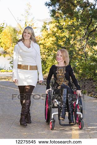 Young paraplegic woman and her friend spending quality time together in a city park in autumn; Edmonton, Alberta, Canada View Large Photo Image Stock Photography - Young paraplegic woman and her friend spending quality time together in a city park in autumn; Edmonton, Alberta, Canada. Fotosearch