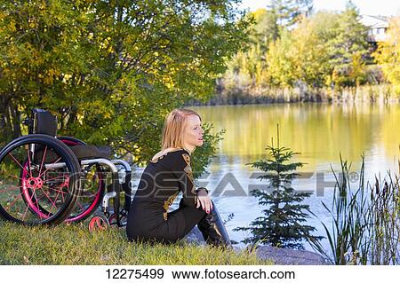 Young paraplegic woman beside her wheelchair by water in a city park in autumn; Edmonton, Alberta, Canada View Large Photo Image Stock Photo - Young paraplegic woman beside her wheelchair by water in a city park in autumn; Edmonton, Alberta, Canada. Fotosearch