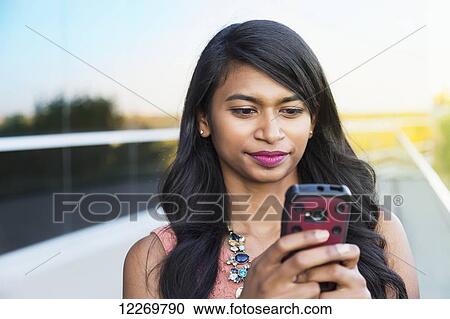 Young professional businesswoman texting on her smart phone; Edmonton, Alberta, Canada View Large Photo Image Stock Image - Young professional businesswoman texting on her smart phone; Edmonton, Alberta, Canada. Fotosearch