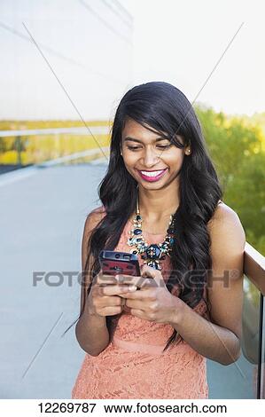 Young professional businesswoman texting on her smart phone; Edmonton, Alberta, Canada View Large Photo Image Stock Photo - Young professional businesswoman texting on her smart phone; Edmonton, Alberta, Canada. Fotosearch