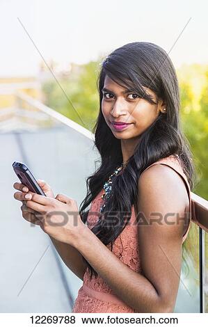 Young professional businesswoman texting on her smart phone; Edmonton, Alberta, Canada View Large Photo Image Stock Photo - Young professional businesswoman texting on her smart phone; Edmonton, Alberta, Canada. Fotosearch