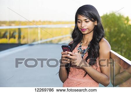 Young professional businesswoman texting on her smart phone; Edmonton, Alberta, Canada View Large Photo Image Stock Photograph - Young professional businesswoman texting on her smart phone; Edmonton, Alberta, Canada. Fotosearch