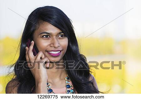 Stock Photography - Young professional businesswoman talking on her smart phone; Edmonton, Alberta, Canada. Fotosearch
