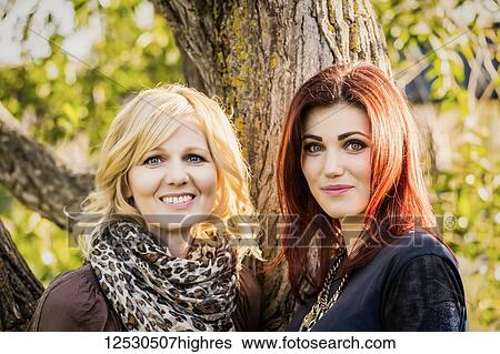 A beautiful mother and daughter pose for a picture in a park just before sunset on a warm fall day; St. Albert, Alberta, Canada View Large Photo Image Stock Photograph - A beautiful mother and daughter pose for a picture in a park just before sunset on a warm fall day; St. Albert, Alberta, Canada. Fotosearch