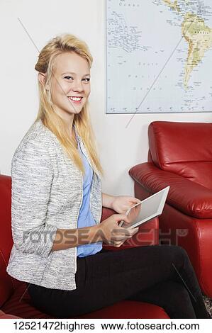 A beautiful young millennial business woman with long blond hair using her tablet in the lobby of a workplace while waiting for a job interview; Sherwood Park, Alberta, Canada View Large Photo Image Stock Photograph - A beautiful young millennial business woman with long blond hair using her tablet in the lobby of a workplace while waiting for a job interview; Sherwood Park, Alberta, Canada. Fotosearch