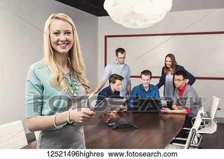 A beautiful young millennial businesswoman posing for the camera in a conference room of young professionals working together in a modern place of business; Sherwood Park, Alberta, Canada View Large Photo Image Stock Photograph - A beautiful young millennial businesswoman posing for the camera in a conference room of young professionals working together in a modern place of business; Sherwood Park, Alberta, Canada. Fotosearch