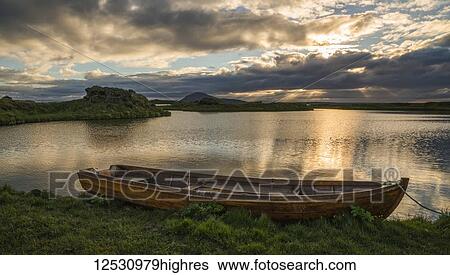 Stock Photograph - A boat lies in a placid Lake Myvatn, North Iceland at sunset; Iceland. Fotosearch