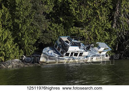 Stock Photograph - A boat shipwrecked along the shores of Clayoquot Sound, Vancouver Island; British Columbia, Canada. Fotosearch