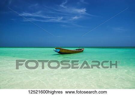 A boat sits in the shallow turquoise waters in a tropical paradise; Andaman Islands, India View Large Photo Image Stock Photograph - A boat sits in the shallow turquoise waters in a tropical paradise; Andaman Islands, India. Fotosearch