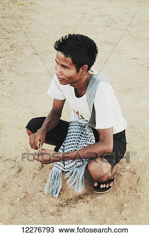 A boy crouches on a dirt ground; Bagan, Myanmar View Large Photo Image Stock Image - A boy crouches on a dirt ground; Bagan, Myanmar. Fotosearch
