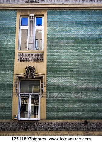 Stock Photograph - A building with green brick and windows with ornate decor; Belgrade, Vojvodina, Serbiade. Fotosearch