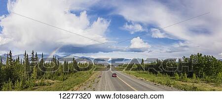 A car drives on the Alaska Highway adjacent to Kluane Lake with atmospheric rain clouds and a Rainbow in the background, Yukon Territory, Canada, Summer View Large Photo Image Stock Image - A car drives on the Alaska Highway adjacent to Kluane Lake with atmospheric rain clouds and a Rainbow in the background, Yukon Territory, Canada, Summer. Fotosearch