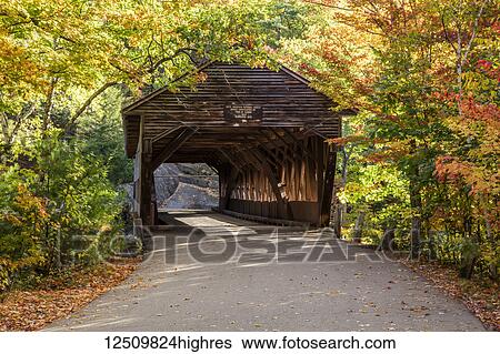 Stock Photograph - A covered bridge on a back country road in autumn, White Mountains National Forest; New England, United States of America. Fotosearch