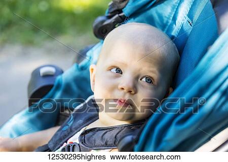 A cute little baby girl sitting in a stroller and looking at something of interest in a park on a warm summer day; Edmonton, Alberta, Canada View Large Photo Image Stock Photograph - A cute little baby girl sitting in a stroller and looking at something of interest in a park on a warm summer day; Edmonton, Alberta, Canada. Fotosearch