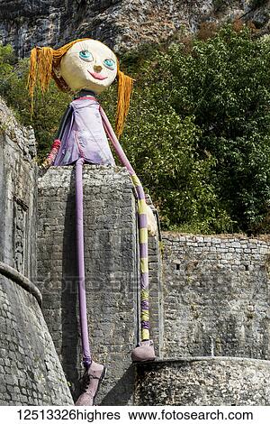 Stock Photograph - A doll with the likeness of a girl sits on a stone wall along the Bay of Kotor; Kotor, Monte. Fotosearch