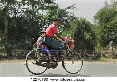 A father and young son riding a bicycle down the road; Bagan, Myanmar View Large Photo Image Stock Image - A father and young son riding a bicycle down the road; Bagan, Myanmar. Fotosearch