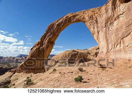 A female hiker sitting under the towering Corona Arch; Moab, Utah, United States of America View Large Photo Image Stock Photograph - A female hiker sitting under the towering Corona Arch; Moab, Utah, United States of America. Fotosearch