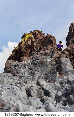 A female tourist poses for a portrait on the top of a rock formation in Western Iceland, Snaefellsnes peninsula; Iceland View Large Photo Image Stock Photograph - A female tourist poses for a portrait on the top of a rock formation in Western Iceland, Snaefellsnes peninsula; Iceland. Fotosearch