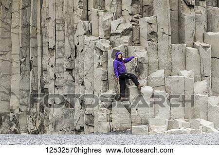 A female tourist poses on the basalt rock columns on the Reynisfjara beach in Southern Iceland; Iceland View Large Photo Image Stock Photograph - A female tourist poses on the basalt rock columns on the Reynisfjara beach in Southern Iceland; Iceland. Fotosearch