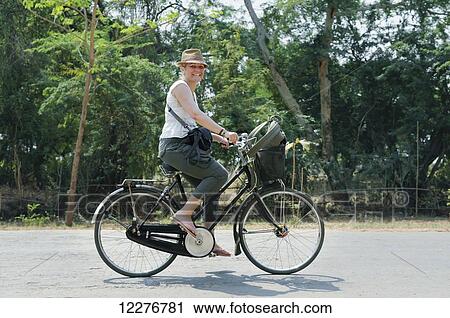 A female tourist rides a bicycle down the street; Bagan, Myanmar View Large Photo Image Stock Image - A female tourist rides a bicycle down the street; Bagan, Myanmar. Fotosearch