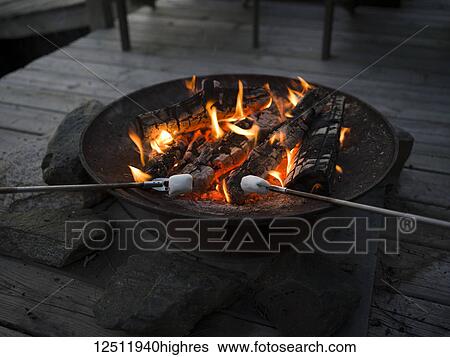 A Fire Pit On A Wooden Deck With Marshmallows Roasting Lake Of