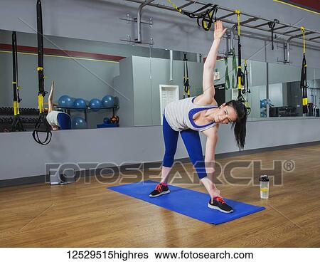 Stock Photograph - A fitness trainer doing a triangle yoga pose at a gym; Spruce Grove, Alberta, Canada. Fotosearch