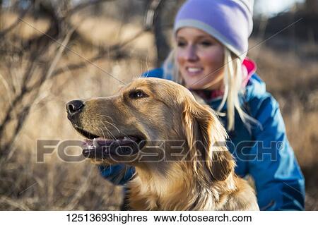 Stock Photograph - A golden retriever with it's female owner; Anchorage, Alaska, United States of America. Fotosearch