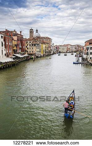 A gondola makes it's way down the Grand Canal; Venice, Italy View Large Photo Image Stock Image - A gondola makes it's way down the Grand Canal; Venice, Italy. Fotosearch