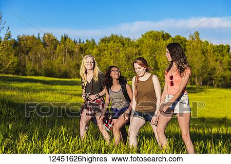 A group of four girlfriends hike together through a field in a park; Edmonton, Alberta, Canada View Large Photo Image Stock Photograph - A group of four girlfriends hike together through a field in a park; Edmonton, Alberta, Canada. Fotosearch