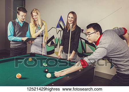 A group of young millennial business professionals playing a game of pool together on a work break; Sherwood Park, Alberta, Canada View Large Photo Image Stock Photograph - A group of young millennial business professionals playing a game of pool together on a work break; Sherwood Park, Alberta, Canada. Fotosearch