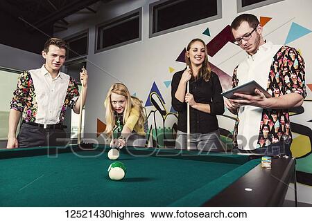 A group of young millennial business professionals playing a game of pool together on a work break; Sherwood Park, Alberta, Canada View Large Photo Image Stock Photograph - A group of young millennial business professionals playing a game of pool together on a work break; Sherwood Park, Alberta, Canada. Fotosearch