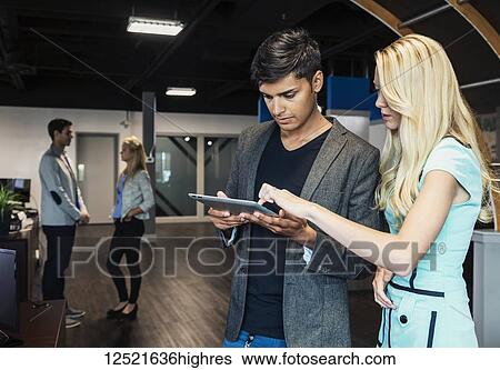 A group of young millennial business professionals in the workplace using technology; Sherwood Park, Alberta, Canada View Large Photo Image Stock Photograph - A group of young millennial business professionals in the workplace using technology; Sherwood Park, Alberta, Canada. Fotosearch
