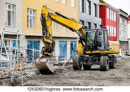 A heavy equipment excavator is parked in front of colourful buildings in downtown Reykjavik, a sign of the booming construction industry in the city; Reykjavik, Iceland View Large Photo Image Stock Photograph - A heavy equipment excavator is parked in front of colourful buildings in downtown Reykjavik, a sign of the booming construction industry in the city; Reykjavik, Iceland. Fotosearch