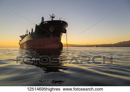 Stock Photograph - A large ship anchored in the tranquil Pacific Ocean off the coast of Vancouver; Vancouver, British Columbia, Canada. Fotosearch