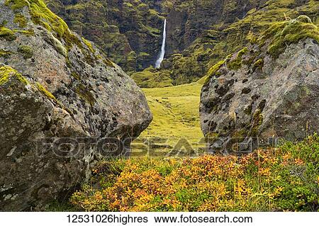 Stock Photograph - A large unnamed waterfall framed by large stone along the south coast of Iceland; Iceland. Fotosearch