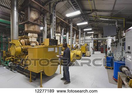 A male Hispanic worker inspects a yellow diesel generator inside an electrical power plant, Prudhoe Bay, Arctic Alaska, USA, Summer View Large Photo Image Stock Photo - A male Hispanic worker inspects a yellow diesel generator inside an electrical power plant, Prudhoe Bay, Arctic Alaska, USA, Summer. Fotosearch