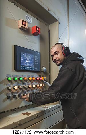 A Male laborer wearing ear protection inspects an electrical power plant control panel, Prudhoe Bay, Arctic Alaska, USA, Summer View Large Photo Image Stock Image - A Male laborer wearing ear protection inspects an electrical power plant control panel, Prudhoe Bay, Arctic Alaska, USA, Summer. Fotosearch
