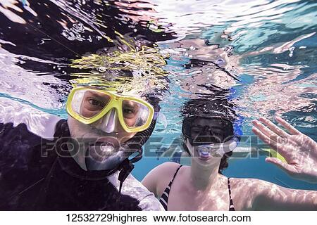 A man and his daughter snorekling and posing for the camera underwater, Turneffe Atoll; Belize View Large Photo Image Stock Photograph - A man and his daughter snorekling and posing for the camera underwater, Turneffe Atoll; Belize. Fotosearch