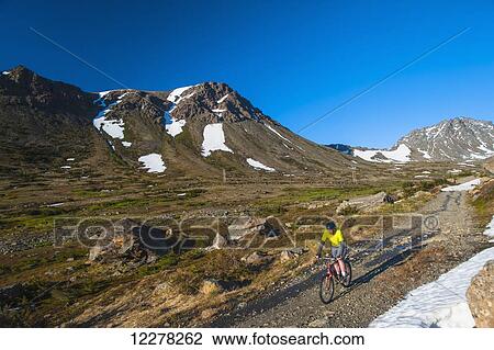 A man riding his bike in Powerline Pass Valley in Chugach State Park on a sunny summer day in Southcentral Alaska. View Large Photo Image Stock Image - A man riding his bike in Powerline Pass Valley in Chugach State Park on a sunny summer day in Southcentral Alaska.. Fotosearch