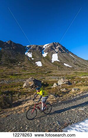 A man riding his bike in Powerline Pass Valley in Chugach State Park on a sunny summer day in Southcentral Alaska. View Large Photo Image Stock Image - A man riding his bike in Powerline Pass Valley in Chugach State Park on a sunny summer day in Southcentral Alaska.. Fotosearch