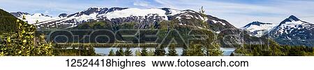 Stock Photograph - A panoramic view of the snow-covered Chugach Mountains and Portage Glacier near the Portage Pass off the Seward Highway; Portage, Alaska, United States of America. Fotosearch