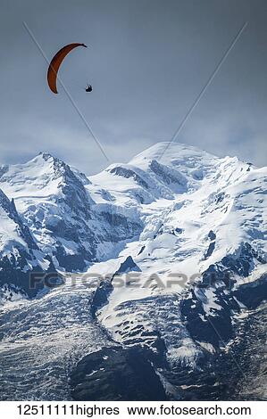 Stock Photograph - A paraglider flying over Mont Blanc; Chamonix-Mont-Blanc, Haute-Savoie, France. Fotosearch