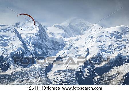 A paraglider flying over Mount Blanc in summer, Alps; Chamonix-Mont-Blanc, Haute-Savoie, France View Large Photo Image Stock Photograph - A paraglider flying over Mount Blanc in summer, Alps; Chamonix-Mont-Blanc, Haute-Savoie, France. Fotosearch