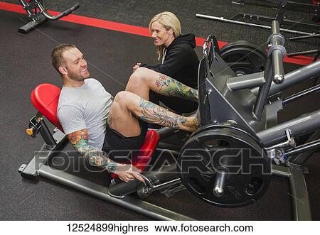 A personal trainer coaching a young man doing leg presses at a fitness facility; Spruce Grove, Alberta, Canada View Large Photo Image Stock Photograph - A personal trainer coaching a young man doing leg presses at a fitness facility; Spruce Grove, Alberta, Canada. Fotosearch