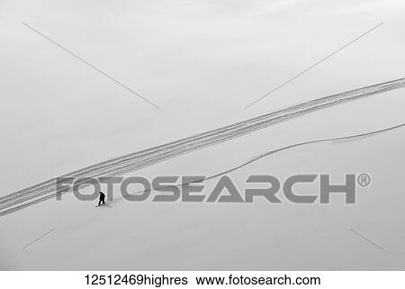 Stock Photograph - A professional, freeriding snowboarder on a wide open snowy slope making new tracks; British Columbia, Canada. Fotosearch