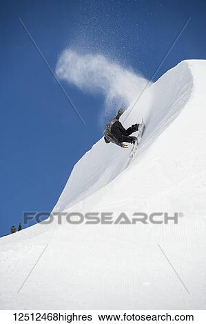 Stock Photograph - A professional snowboarder on a slope, Grand Targhee Resort, Peace Park 2016; Wyoming, United States of America. Fotosearch