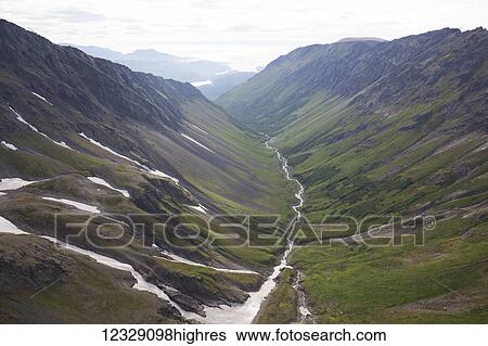 Stock Photograph - A river running through a valley in the Kenai Mountains, Kachemak Bay State Park; Alaska, United States of America. Fotosearch