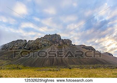 Stock Photograph - A rugged rocky mountain landscape at sunset in the summer; Iceland. Fotosearch